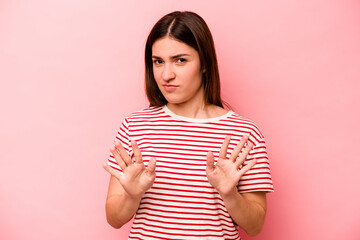 Young caucasian woman isolated on pink background rejecting someone showing a gesture of disgust.