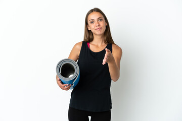 Sport woman going to yoga classes while holding a mat over isolated white background shaking hands for closing a good deal