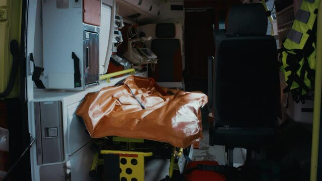 Beautiful Young Ethnic Female Emergency Care Worker Coming Towards The Ambulance Car To Pick Up the Bag and Get To Work, Behind Her An Ambulance Car With All The Equipment.