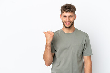 Fototapeta premium Young caucasian handsome man isolated on white background pointing to the side to present a product