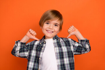 Photo of young cheerful boy indicate thumbs himself choice choose isolated over orange color background