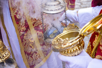 Detail of the hand of an altar boy or acolyte in a Holy Week procession filling one of the censers...