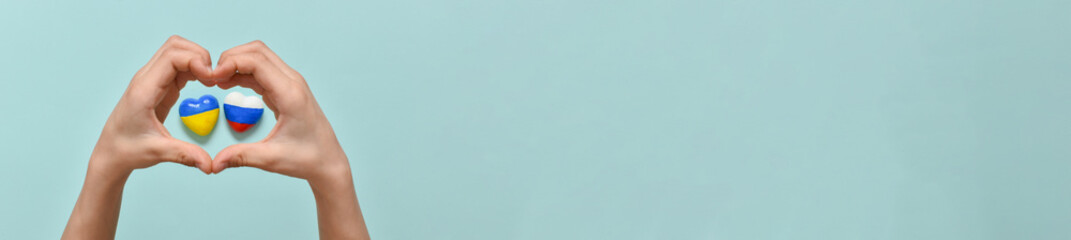 Banner children's hands hold a heart with the flags of the countries of Russia and Ukraine. Geopolitical conflict