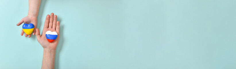 selective focus. Banner children's hands hold a heart with the flags of the countries of Russia and Ukraine.