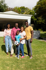 Portrait of happy african american multi-generational family standing together in front yard