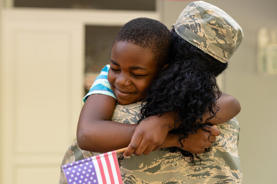 African american boy embracing soldier mother on arrival at home