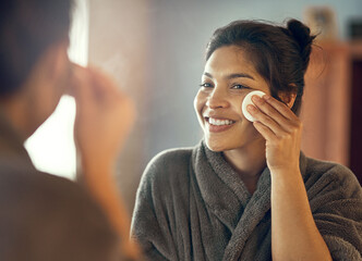 An investment in healthy skin lasts a lifetime. Shot of a smiling young woman taking care of her...