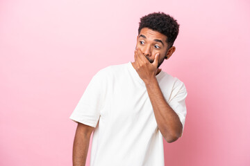 Fototapeta na wymiar Young Brazilian man isolated on pink background doing surprise gesture while looking to the side
