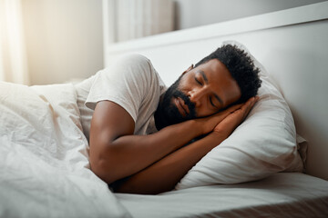 Sleeping in over the weekend. Cropped shot of a handsome young man sleeping in bed at home.