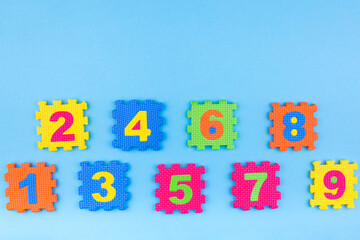 Colorful kids numbers toys on blue background. Education concept. Creative concept. Flat lay, copy space, top view.