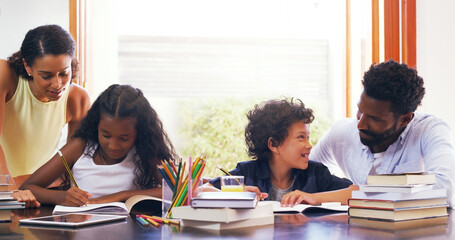 Helping the little ones with their homework. Cropped shot of parents helping their two children with their schoolwork at home.