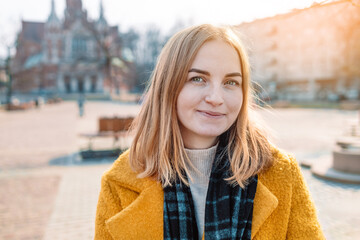 Portrait of smiling european 30 woman strolling through city street 