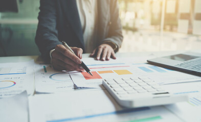 Accountant working on desk using calculator for calculate finance report in office.