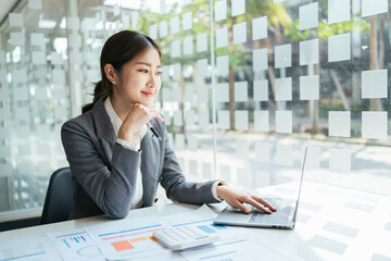Asian woman working in the office using a laptop.