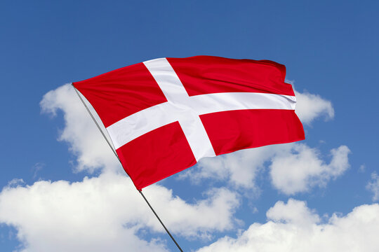 3d illustration. A beautiful view of Denmark flag on a blue sky background.