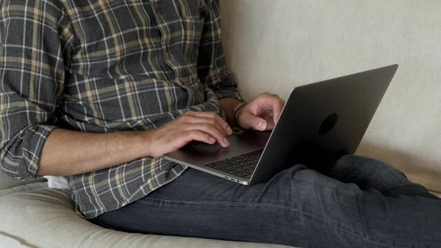 Close up of a focused and serious man working from home. Slow motion, handheld. Remote working anywhere, digital nomad concept
