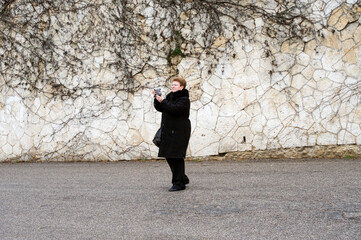 Seize the opportunity to film. Caucasian woman in the street with a video camera.
