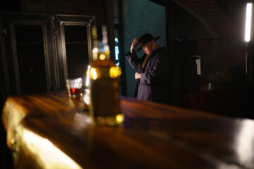Portrait of brutal man with beard in hat in interior of bar