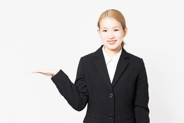案内のポーズをするジャケットを着た女性