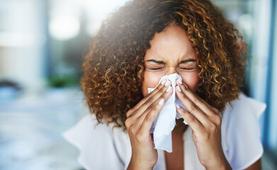 I think Im going to the doctor later. Shot of a frustrated businesswoman using a tissue to sneeze...