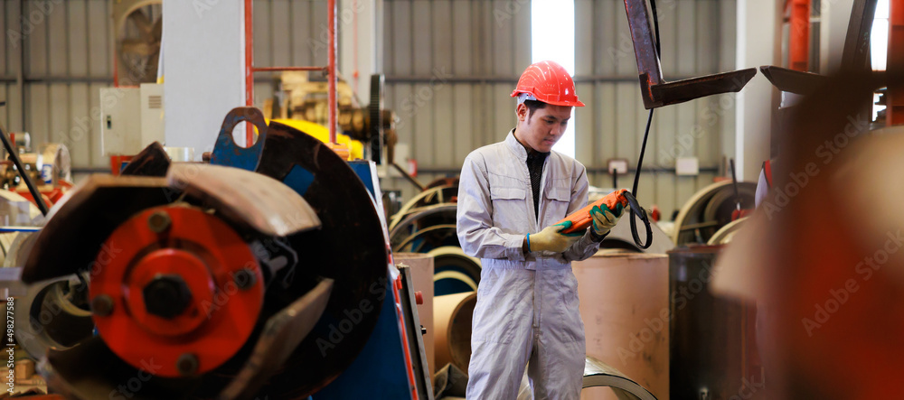 Poster Close up worker hands control indoor overhead crane to lift up metal construction object on metal sheet factory.