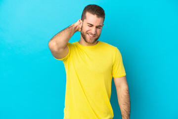 Young handsome caucasian man isolated on blue background with neckache