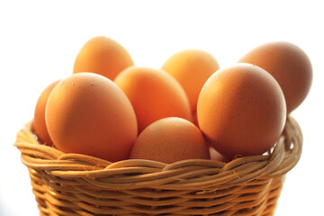A basket of chicken eggs in warm light on a wooden table
