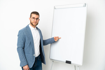 Young handsome caucasian man isolated on white background giving a presentation on white board