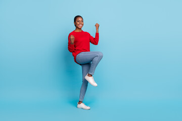 Full length photo of celebrate millennial brunette lady hands fists wear shirt jeans footwear isolated on blue background