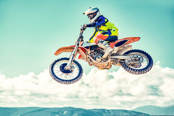 Extreme concept, challenge yourself. Extreme jump on a motorcycle on a background of blue sky with...