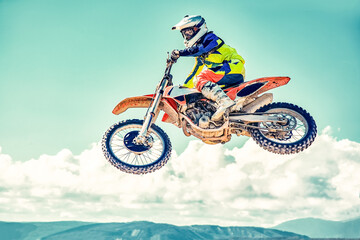 Extreme concept, challenge yourself. Extreme jump on a motorcycle on a background of blue sky with clouds. Copy space, all or nothing.