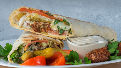 Plate of falafel with pita bread, vegetables and tzatziki sauce. Arabian meal, hummus and falafel.