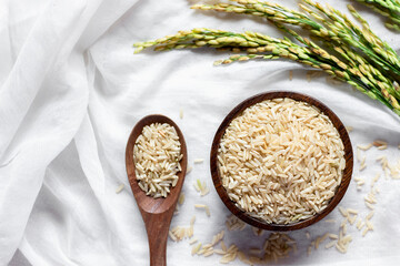 The rice grains in a wooden cup are placed in a cradle on a white cloth.