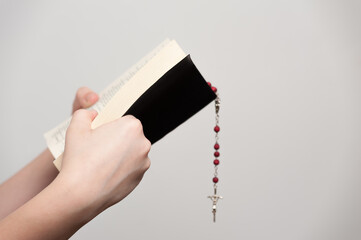 hands of a young man holding an open Holy Bible during of a pray