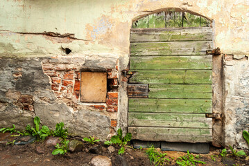Old red brick house with green wooden doors.