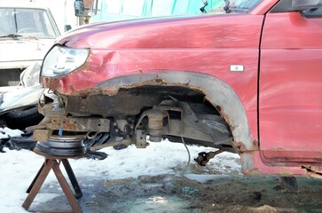 old car under repair, front wheel removed