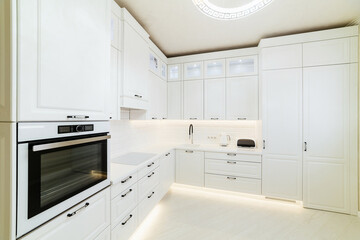 large white kitchen for cooking with appliances and lighting