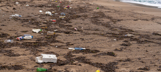 Garbage on the beach, world ocean pollution. Dirty sea sandy shore. Ocean pollution concept with plastic and garbage