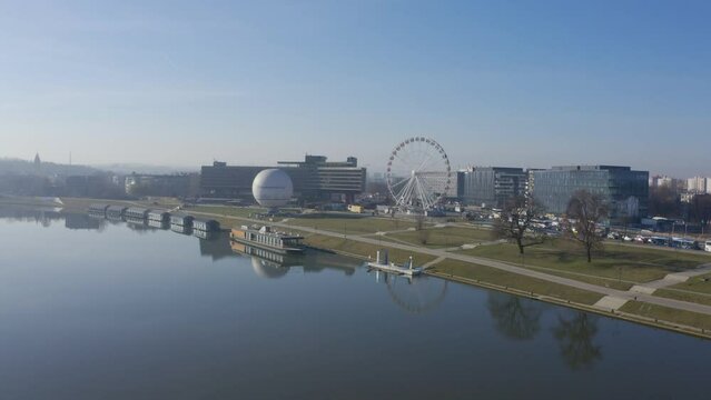 Krakow Poland. River Visla ( Vistula), ballon and Ferris wheel. Aerial video footage drone crosses the river and approaches the sights. Calm foggy panorama of morning city from above