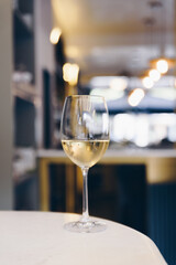 Glass with white wine on table