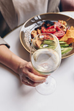 Woman having her lunch and she is holding glass of white wine