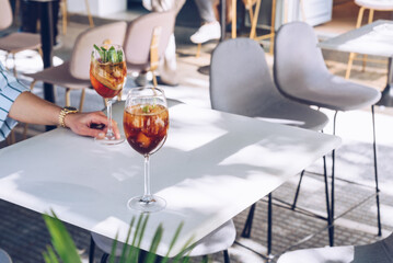 Woman is holding a glass of cocktail, summer days
