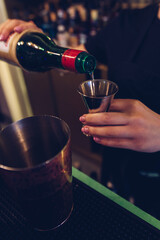 Girl bartender is making cocktail at bar.