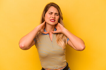 Young caucasian woman isolated on yellow background suffering neck pain due to sedentary lifestyle.