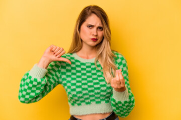 Young caucasian woman isolated on yellow background showing that she has no money.