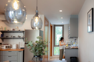 Positive Asian woman housewife cooking healthy vegetarian food at kitchen home. Happy woman doing domestic chores. Asian woman cut vegetables on kitchen table