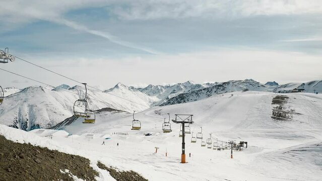 Livigno, Italy - February 21, 2022: aerial view of Livigno ski resort in Lombardy, Italy. Chairlifts, ski lifts, gondola cabin are moving and skiers skiing over scenery panorama. 4k video footage 