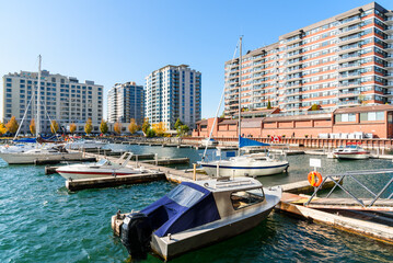 Fototapeta na wymiar Marina surrounded by high rise condos on a sunny autumn day. Kingston, ON, Canada.