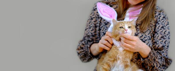 Girl and ginger cat in bunny ears, cat in suit for easter, banner with copy space