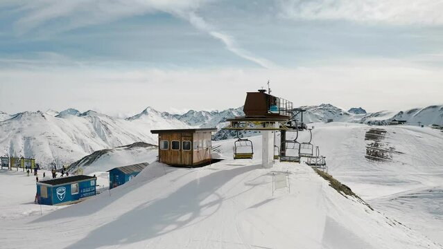 Livigno, Italy - February 21, 2022: Aerial view of Livigno ski resort in Lombardy, Italy. Chairlifts, ski lifts, gondola cabin are moving and skiers skiing over scenery panorama. 4k video footage 